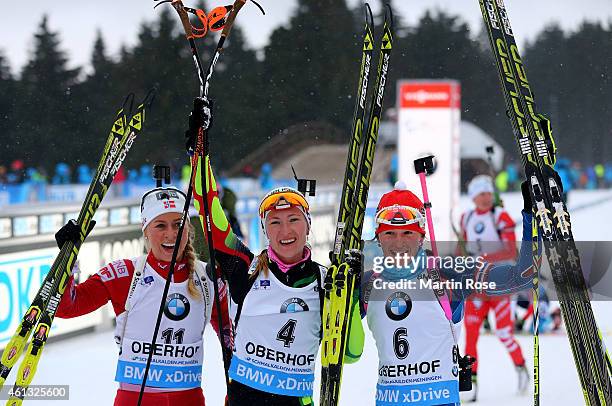 Darya Domracheva of Belarus celebrate with Tiril Eckhoff of Norway and Veronika Vitkova of Czech Republic after crossing the finish line during the...