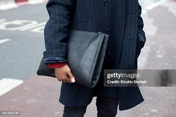 Fashion and celebrity stylist Jay Xyyx wearing villain coat, Topman jeans and boots, clutch bag from a vintage boutique on day 2 of London...