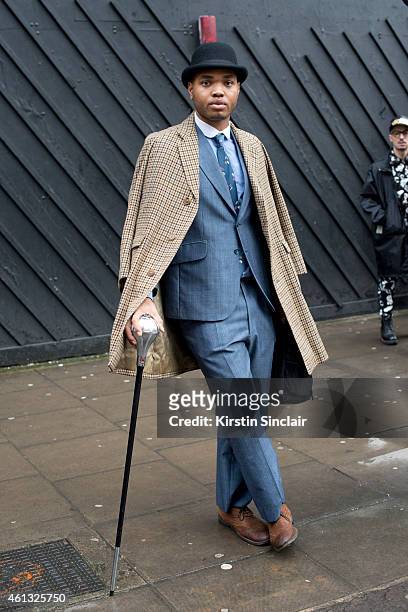 Fashion blogger Omiri Thomas wearing a vintage coat and hat, vintage Burton suit and Ted Baker shoes on day 2 of London Collections: Men on January...