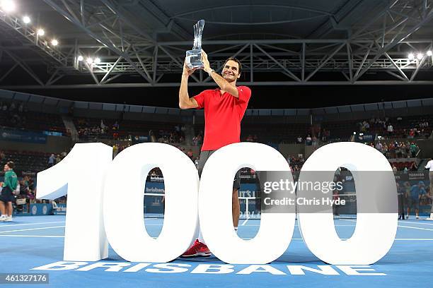 Roger Federer of Switzerland holds the Roy Emerson trophy after winning his 1000 singles title after the Mens final match against Milos Raonic of...