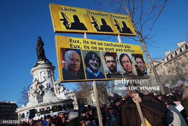 Man holds a sign bearing the portraits of late Charlie Hebdo editor Stephane Charbonnier , late French cartoonists Georges Wolinski, Jean Cabut ,...