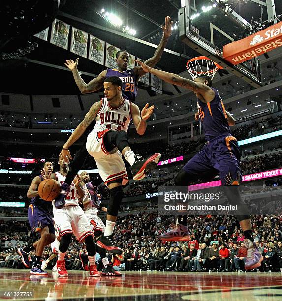 Augustin of the Chicago Bulls passes the ball behind to Jimmy Butler as Archie Goodwin and Marcus Morris of the Phoenix Suns defend at the United...