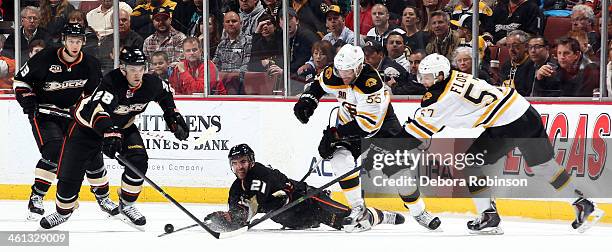 Kyle Palmieri and Mark Fistric of the Anaheim Ducks battle for the puck against Johnny Boychuk and Justin Florek of the Boston Bruins on January 7,...