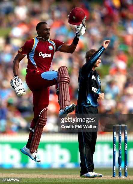 Dwayne Bravo of the West Indies celebrates his century as Kane Williamson of New Zealand looks on during game five of the One Day International...