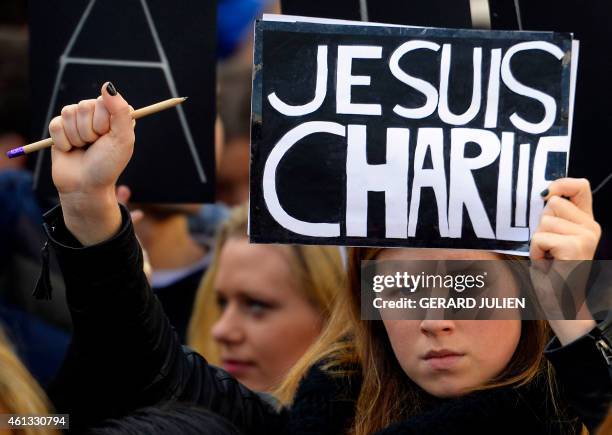 Woman holds placard reading in French "I am Charlie" during a public show of solidarity on Plaza del Sol in Madrid on January 11, 2015 and to protest...