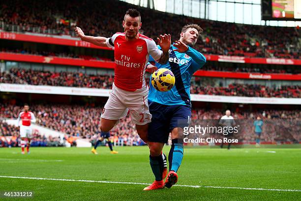 Mathieu Debuchy of Arsenal is challenged by Marko Arnautovic of Stoke City and subsequently picks up an injury during the Barclays Premier League...