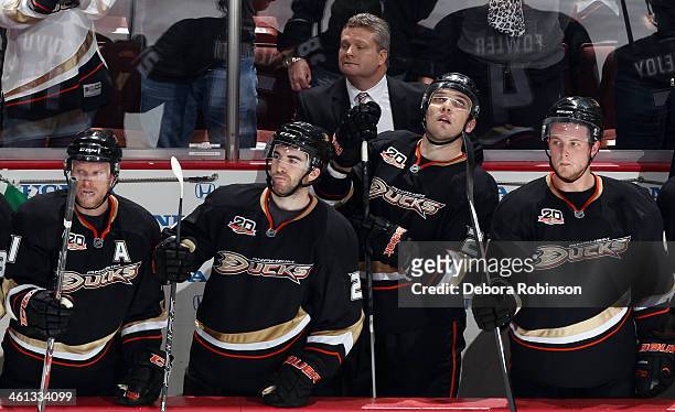 Saku Koivu, Kyle Palmieri, Mark Fistric and Cam Fowler of the Anaheim Ducks watch the action from the bench during the game against the Boston Bruins...