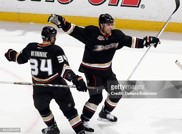 Andrew Cogliano and Daniel Winnik of the Anaheim Ducks celebrate Cogliano's goal scored in the second period of the game against the Boston Bruins on...