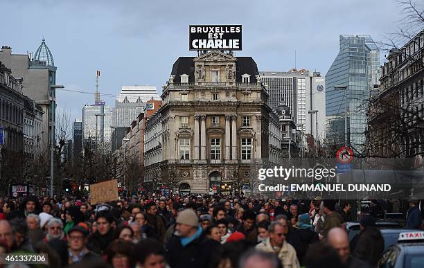 Some 20,000 people march in front of a sign, reading "Brussels is Charlie" on January 11, 2015 in Brussels in tribute to the 17 victims of the...