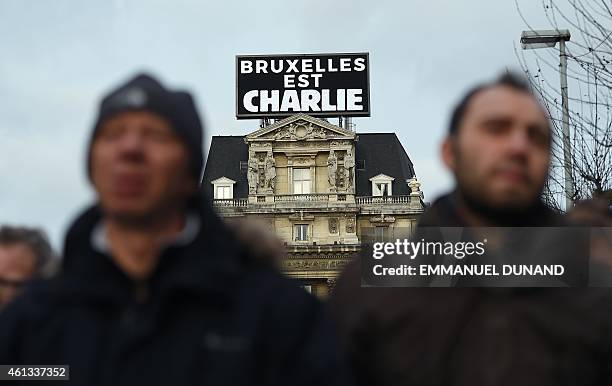 Some 20,000 people march in front of a sign, reading "Brussels is Charlie," on January 11, 2015 in Brussels in tribute to the 17 victims of the...