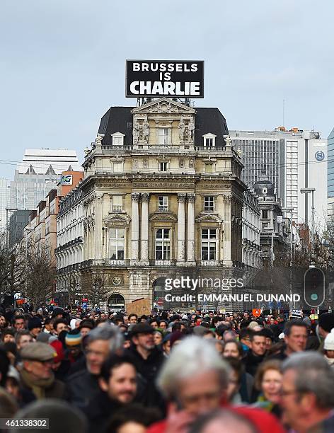 Some 20,000 people march on January 11, 2015 in Brussels in front of a sign, reading "Brussels is Charlie," in tribute to the 17 victims of the...