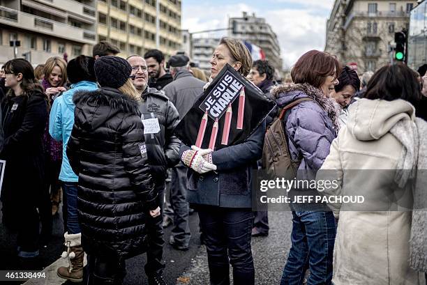 Woman holds a placard reading "Je suis Charlie" during a Unity rally Marche Republicaine on January 11, 2015 in Lyon in tribute to the 17 victims of...