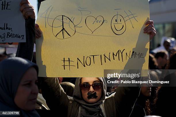 Protester holds a placard reading 'Not in my name' amid other Muslim protesters during a demonstration outside Atocha Station against the recent...