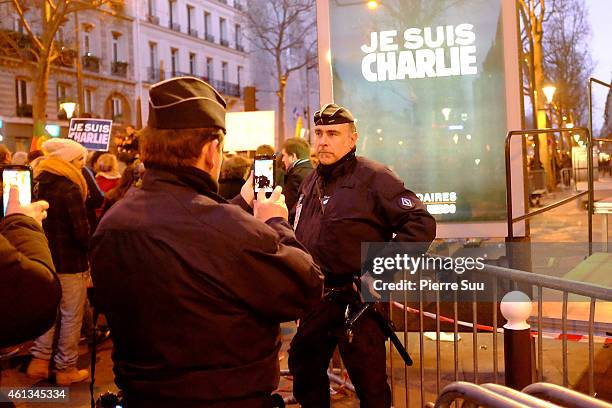 Policemen takes a photo during a mass unity rally following the recent terrorist attacks on January 11, 2015 in Paris, France. An estimated one...