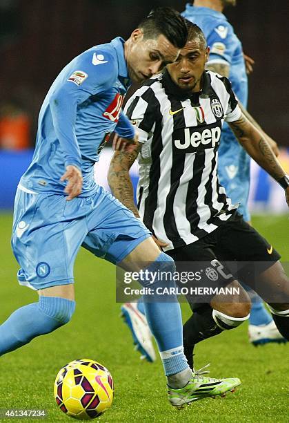 Napoli's Spanish forward Jose Maria Callejon fights for the ball with Juventus' Chilean midfielder Arturo Vidal during the Italian Serie A football...