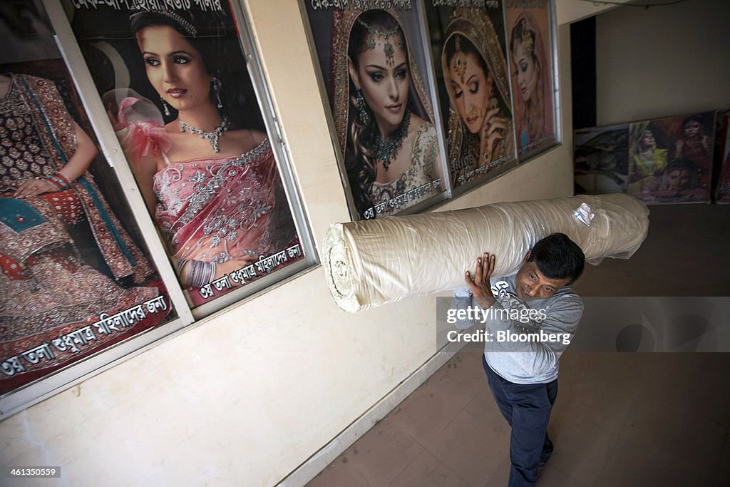 A garment factory worker carries a roll of fabric in a garment... News ...