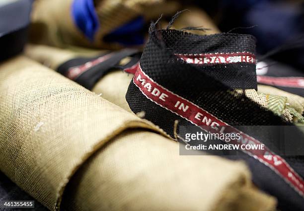 Clothing label is pictured inside clothing shop Henry Poole and Co in London, on January 6, 2014. In a basement workshop on Savile Row, it is hard to...
