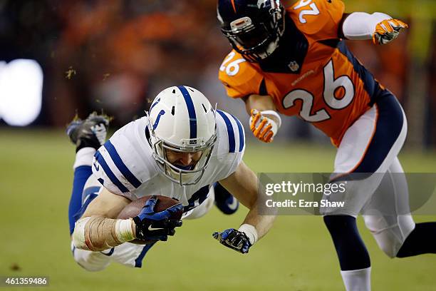 Jack Doyle of the Indianapolis Colts dives after a catch as Rahim Moore of the Denver Broncos covers the play during a 2015 AFC Divisional Playoff...