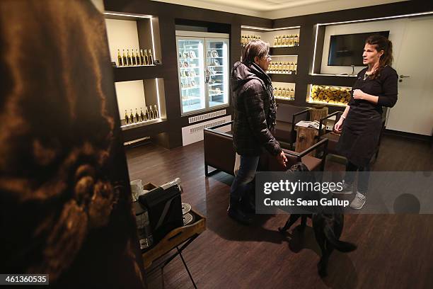 Store employee Katharina chats with a customer as Lilly, a female labrador, seels attention at Pets Deli, a newly-opened upscale food store that...