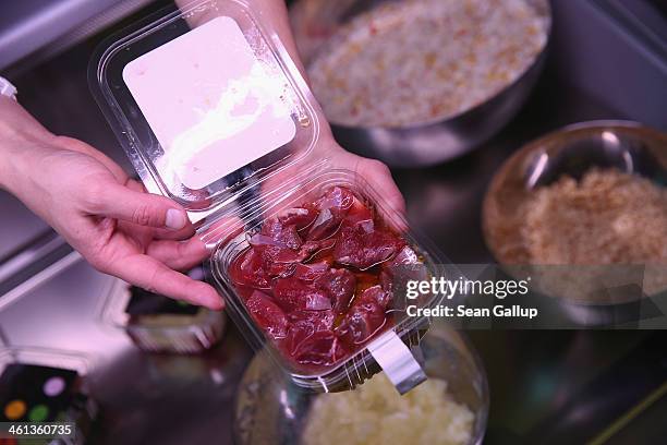 Store employee displays a container of kangaroo meat mixed with linseed oil at Pets Deli, a newly-opened upscale food store that caters specifically...