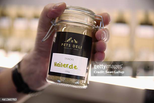 Store employee displays a container of "healing earth", which is a mixture of subtances that neutralize toxins in the digestive tract of a dog, at...