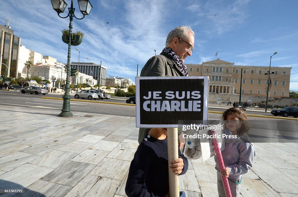 A boy holds a picket with the phrase 'Je Suis Charlie' on it...