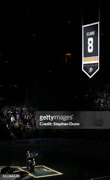 Former Anaheim Ducks star Teemu Selanne stands with his family as his banner is raised during ceremonies retiring Selanne's number by the Ducks...