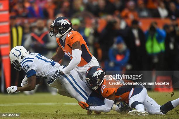 Broncos cornerback Aqib Talib and safety Rahim Moore tackle Colts wide receiver T.Y. Hilton after a catch on Sunday, Jan. 11 at Sports Authority...
