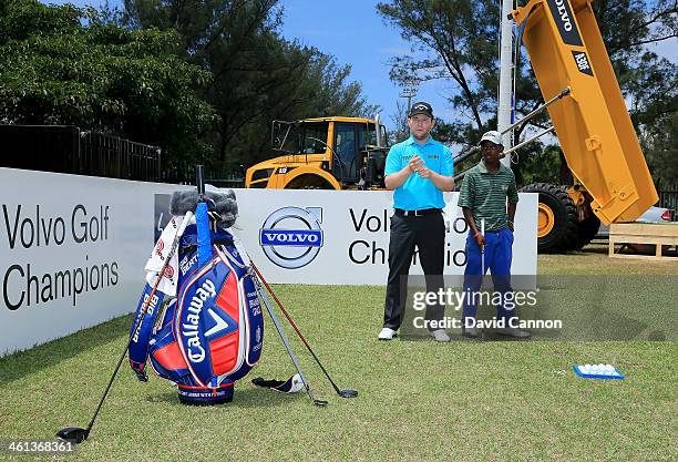 Branden Grace of South Africa conducts a Junior Clinic on the driving range during the pro-am as a preview for the 2014 Volvo Golf Champions...