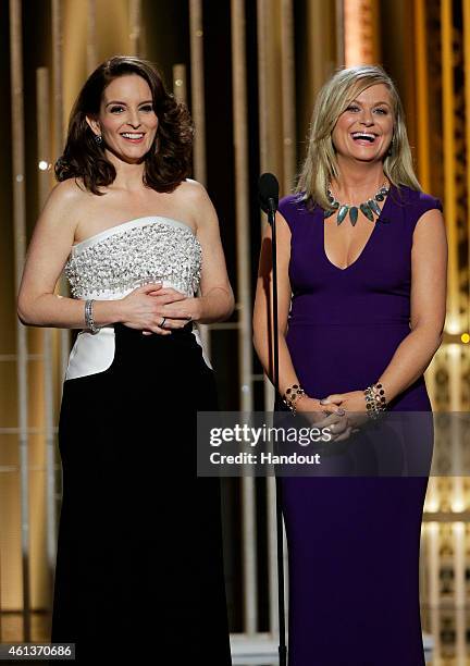 In this handout photo provided by NBCUniversal, Hosts Tina Fey and Amy Poehler speak onstage during the 72nd Annual Golden Globe Awards at The...