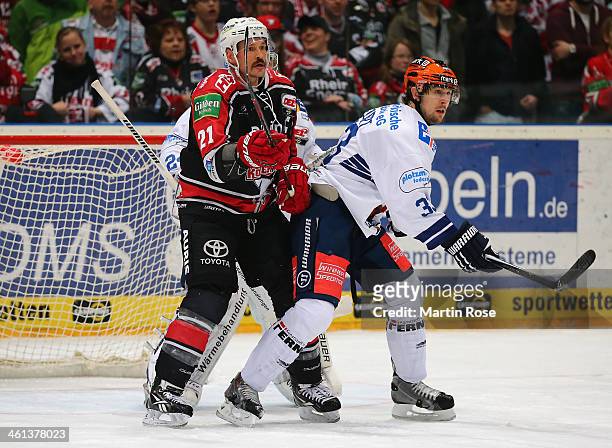 John Tripp of Koeln battles for position with Colten Teubert of Iserlohn Roosters during the DEL match between Koelner Haie and Iserlohn Rooster at...