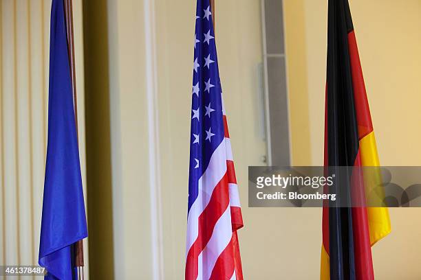 The flags of the European Union, left, the U.S., center, and Germany are seen at the German finance ministry ahead of a news conference in Berlin,...