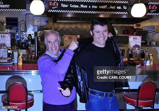 Actor Henry Winkler poses passing a leather jacket to British actor Ben Freeman during a photocall at Ed's Easy Diner in central London on January 8,...