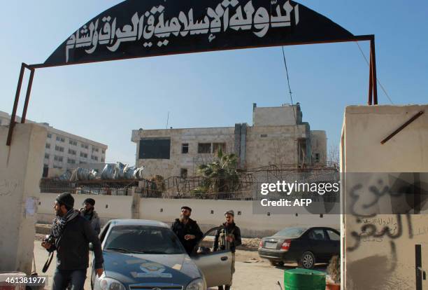 Rebel fighters stand at an entrance of the Aleppo headquarters of the Islamic State of Iraq and the Levant in the northern city of Aleppo after...