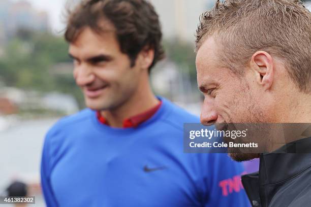 Lleyton Hewitt and Roger Federer are given instuctions on a game of 'speed boat tennis' that they are about to play Sydney Habour on January 12, 2015...