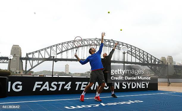 Roger Federer of Switzerland and Lleyton Hewitt of Australia hit some balls for the cameras during the launch of Fast 4 Tennis in front of the Sydney...