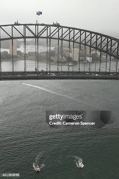 Roger Federer of Switzerland plays tennis with Lleyton Hewitt of Australia between speedboats on Sydney Harbour ahead of their Fast 4 Exhibition...