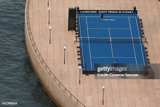 Roger Federer of Switzerland plays tennis with Lleyton Hewitt of Australia on the forecourt of the Sydney Opera House ahead of their Fast 4...