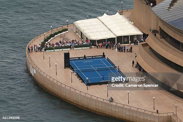 Roger Federer of Switzerland plays tennis with Lleyton Hewitt of Australia on the forecourt of the Sydney Opera House ahead of their Fast 4...