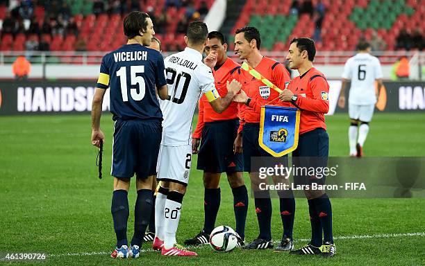 Farid Mellouli of ES Setif and Ivan Vicelich of Auckland City FC pose with the referees during the FIFA Club World Cup Quarter Final match between ES...