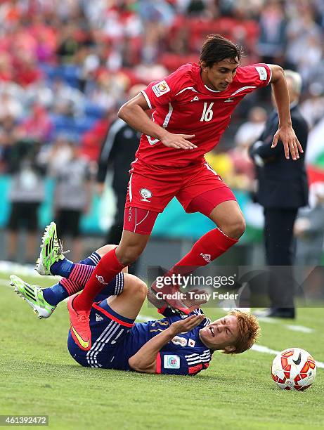 Mahmoud Dhadha of Palestine jumps over Gotoku Sakai of Japan during the 2015 Asian Cup match between Japan and Palestine at Hunter Stadium on January...