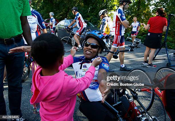 Marathon survivor Mery Daniel, right, hugs her daughter, Ciarra as she prepares to ride on her handbike as part of a Spaulding Rehab group that is...