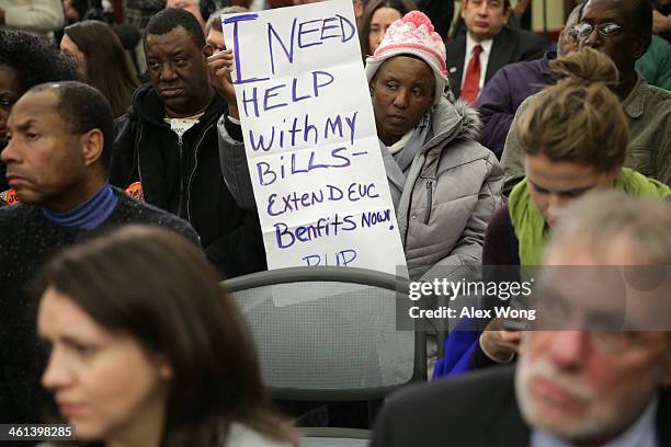 Jacqueline Chapman of Philadelphia holds a poster during a news conference January 8, 2014 on Capitol Hill in Washington, DC. U.S. House Minority...