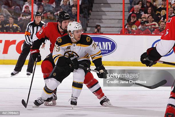 David Warsofsky the Boston Bruins skates against Matt Kassian of the Ottawa Senators during an NHL game at Canadian Tire Centre on December 28, 2013...