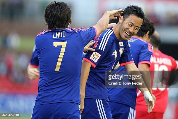 Maya Yoshida of Japan celebrates scoring his team's fourth goal with team mate Yasuhito Endo during the 2015 Asian Cup match between Japan and...