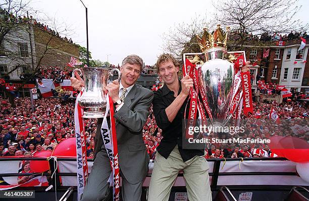 Arsenal manager Arsene Wenger and captain Tony Adams hold the FA Cup and Premiership trophy outside Islington Town Hall on May 12, 2002 London,...