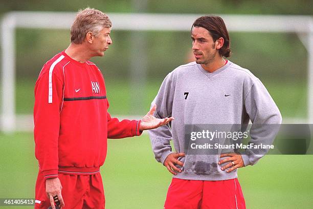 Arsenal manager Arseen Wenger with Robert Pires during a training session at London Colney on September 16, 2002 in St Albans, England.