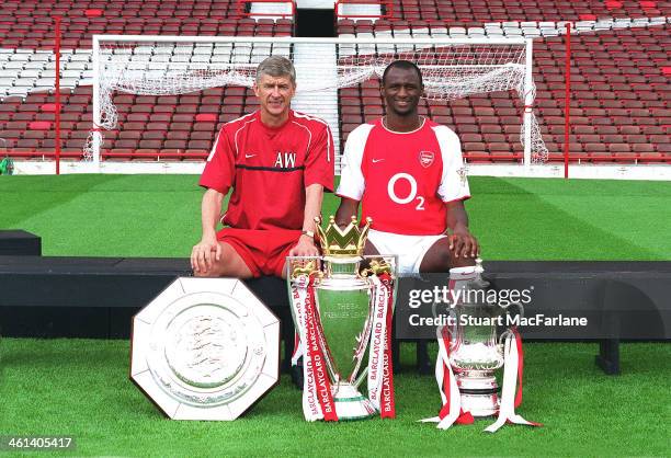 Arsenal manager Arsene Wenger poses with captain Patrick Vieira and the Community Shield, Premier Leage trophy and FA Cup at Arsenal Stadium,...