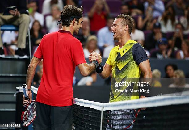 Roger Federer of Switzerland shakes hands with Lleyton Hewitt of Australia after their match at Qantas Credit Union Arena on January 12, 2015 in...