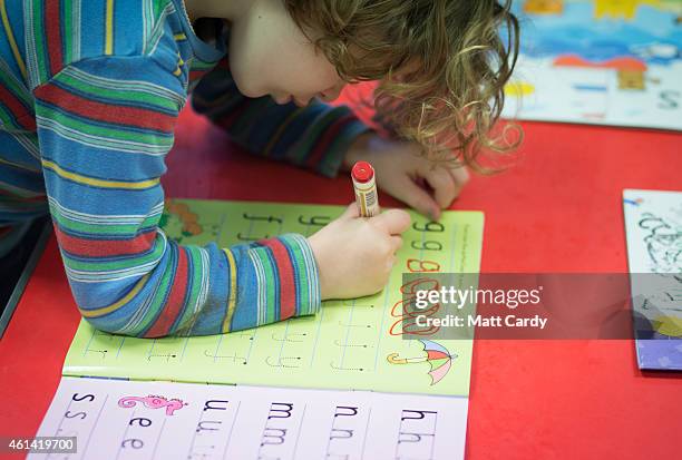 Young girl writes letters at a playgroup for pre-school aged children in Chilcompton near Radstock on January 6, 2015 in Somerset, England. Along...